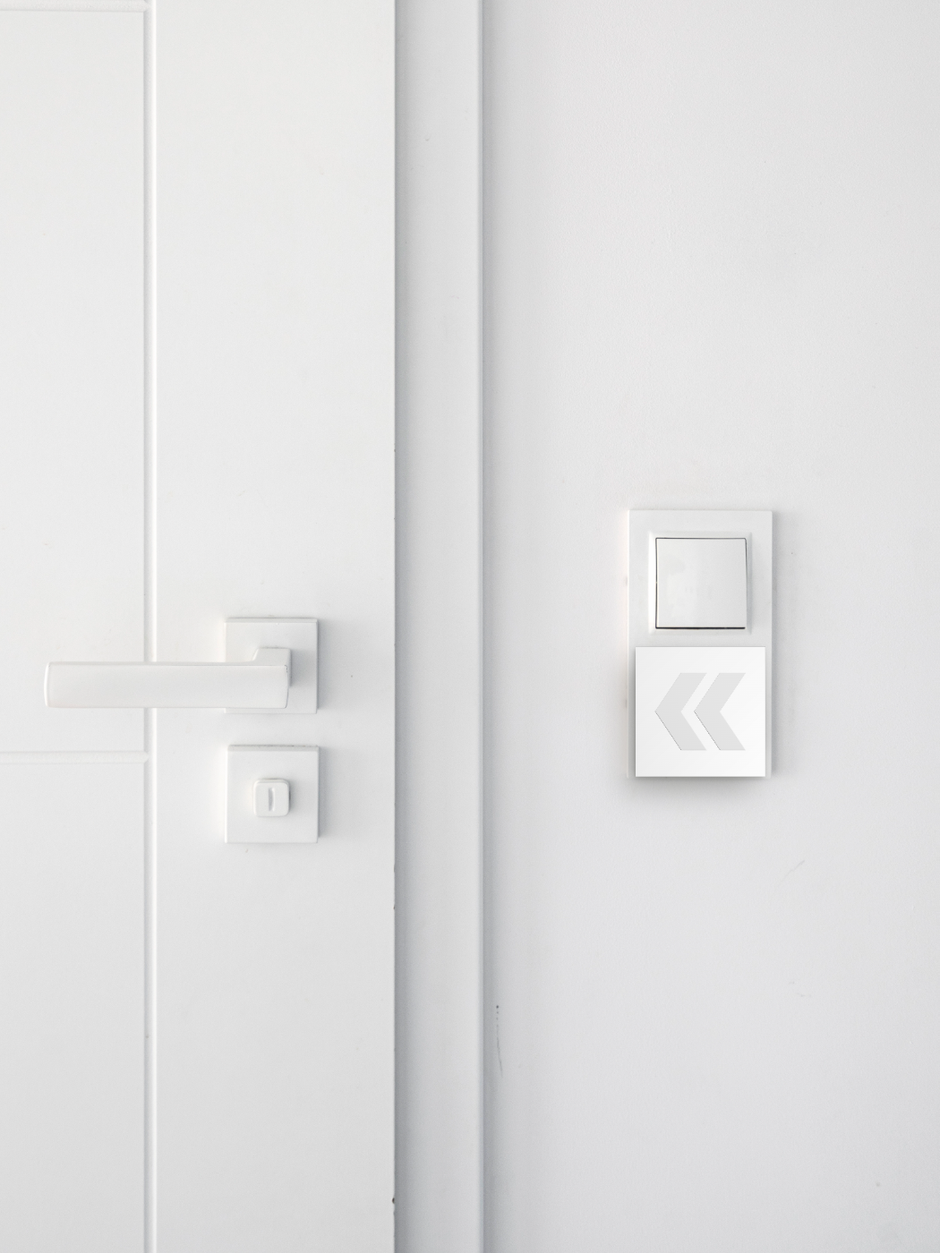 PanicLite neben einem Lichtschalter an der Wand / PanicLite next to a light switch on the wall